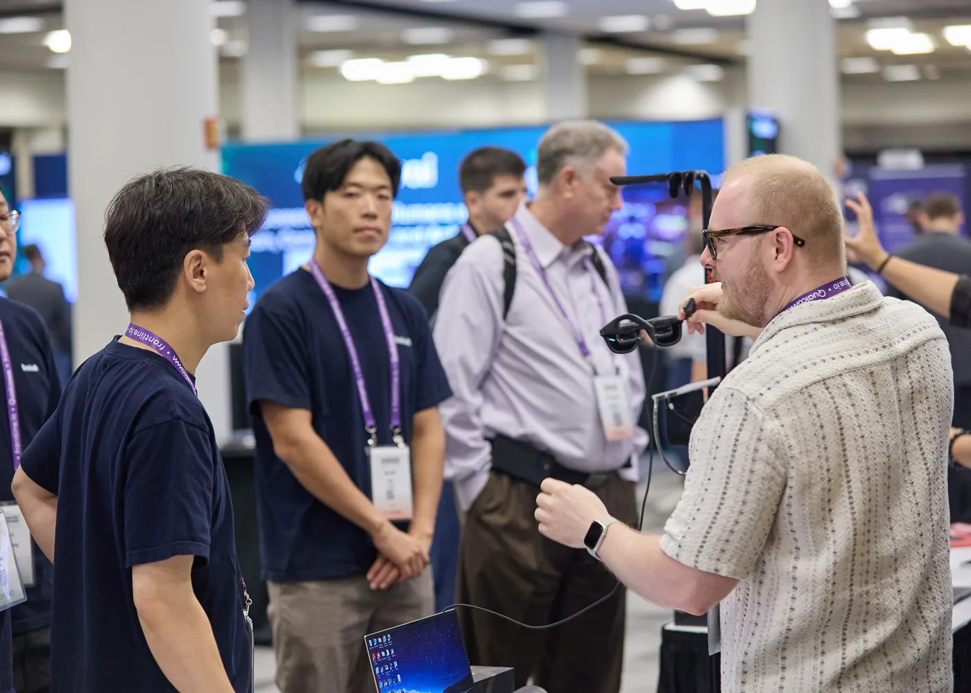 Enterprise technology professionals discussing a device on the expo floor